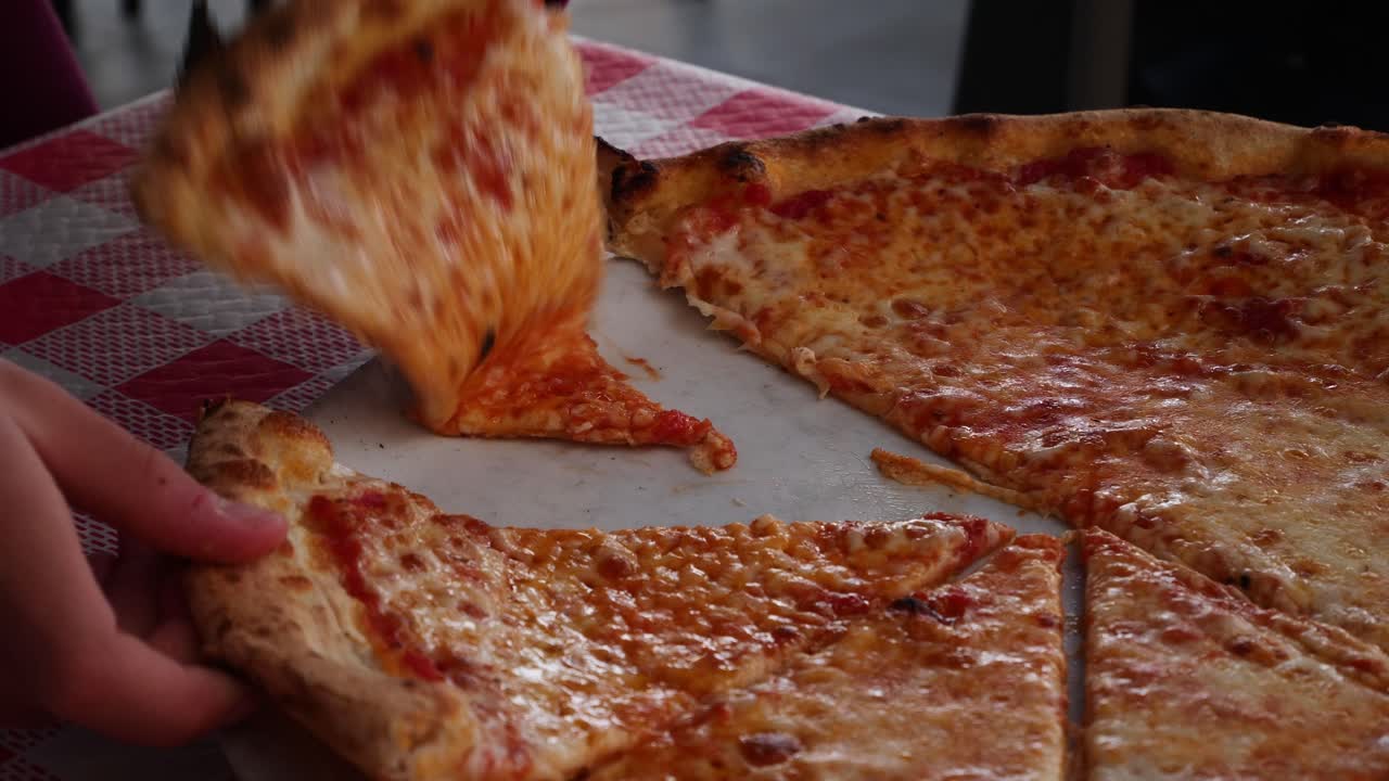 Bambino che separa due fette di pizza Margherita. Rallentatore x0,5.