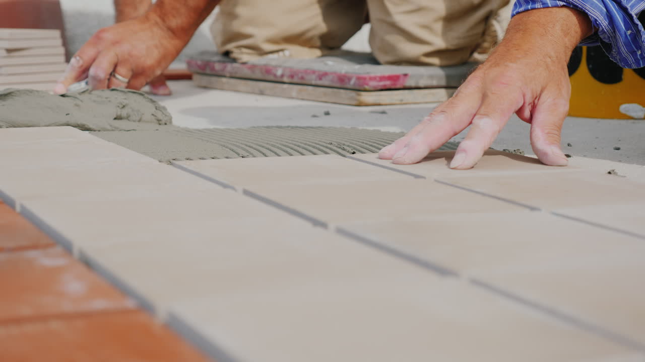 Worker Hands Laid Tile On The Floor On An Open Veranda