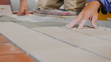 Worker-Hands-Laid-Tile-On-The-Floor-On-An-Open-Veranda