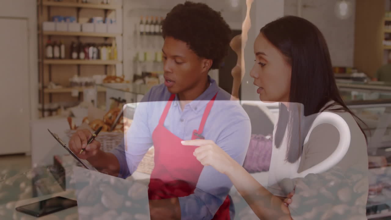 Bakery staff updating inventory behind glass countertop, overlaying animated baked goods icons