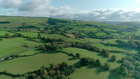 aerial overlooking glorious green fields in the hilly countryside of powys, wales