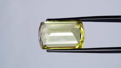 natural yellow citrine in the tweezer on the turning table