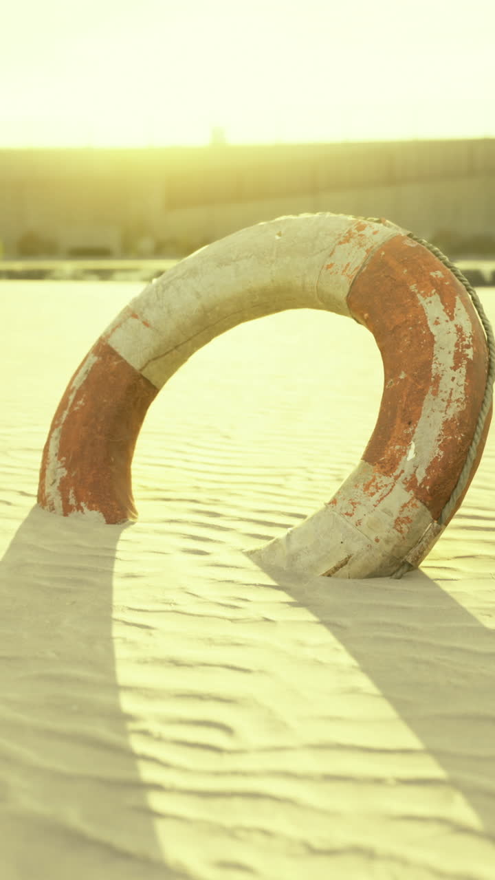 Sun kissed lifebuoy casting shadows on serene golden sands at sunset