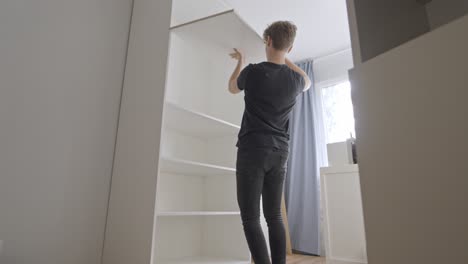 carpenter assembling shelves, static wide