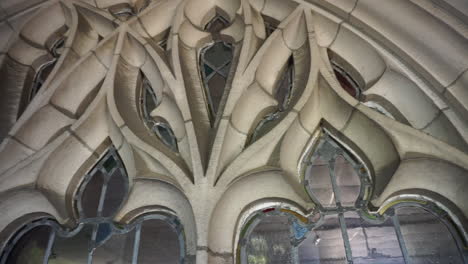 camera pans over stonework tracery and leaded glass window