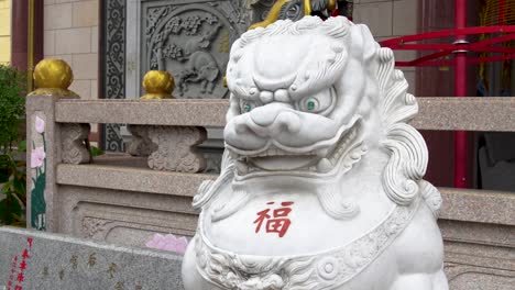 a statue of a dragon lion outside of the thien hau temple in chinatown of los angeles, california