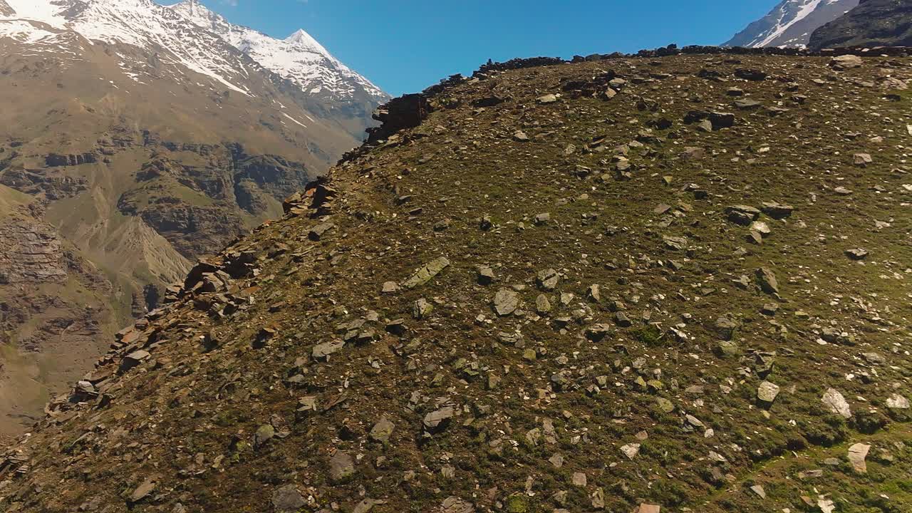 4k fly up drone shot revelando las cordilleras nevadas del himalaya con un profundo desfiladero en el medio con un río que lo atraviesa y múltiples cascadas