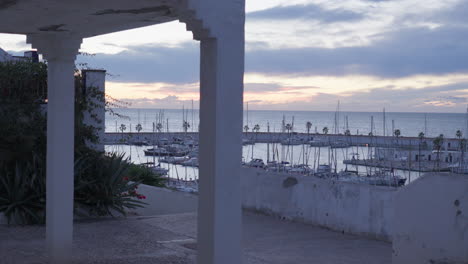 port village is tranquil as yachts are parked in a calm sea during the golden hour