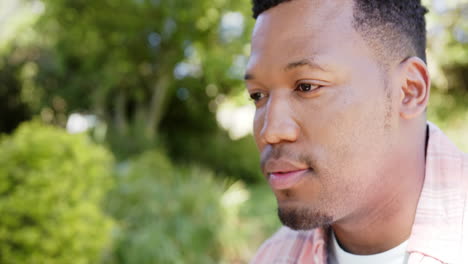 thoughtful african american man in garden at home, slow motion