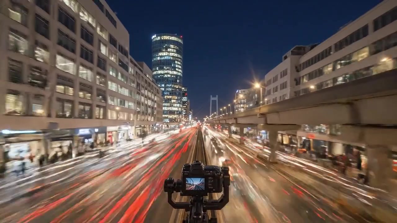 Fængslende time-lapse rejse: En fantastisk overgang fra dag til nat over en travl bygade med dynamisk bevægelse og levende bylys.