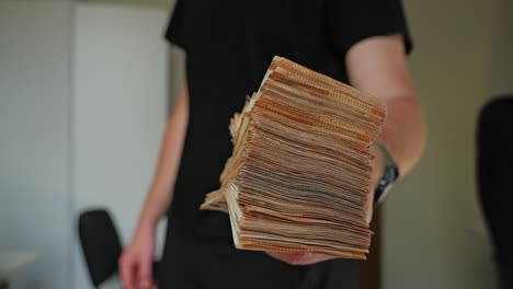 slow motion of money lending concept as man offers thick euro bundle forward