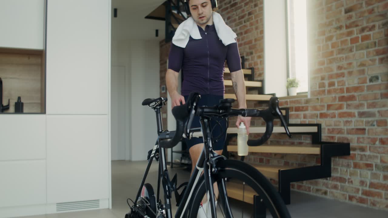 집 에서 실내 사이클링 자전거 를 타고 일 하는 사람