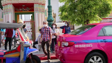 tuk-tuks and pedestrians in a lively street crossing