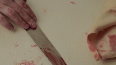 bloody hand struggles to get bloody knife after fight