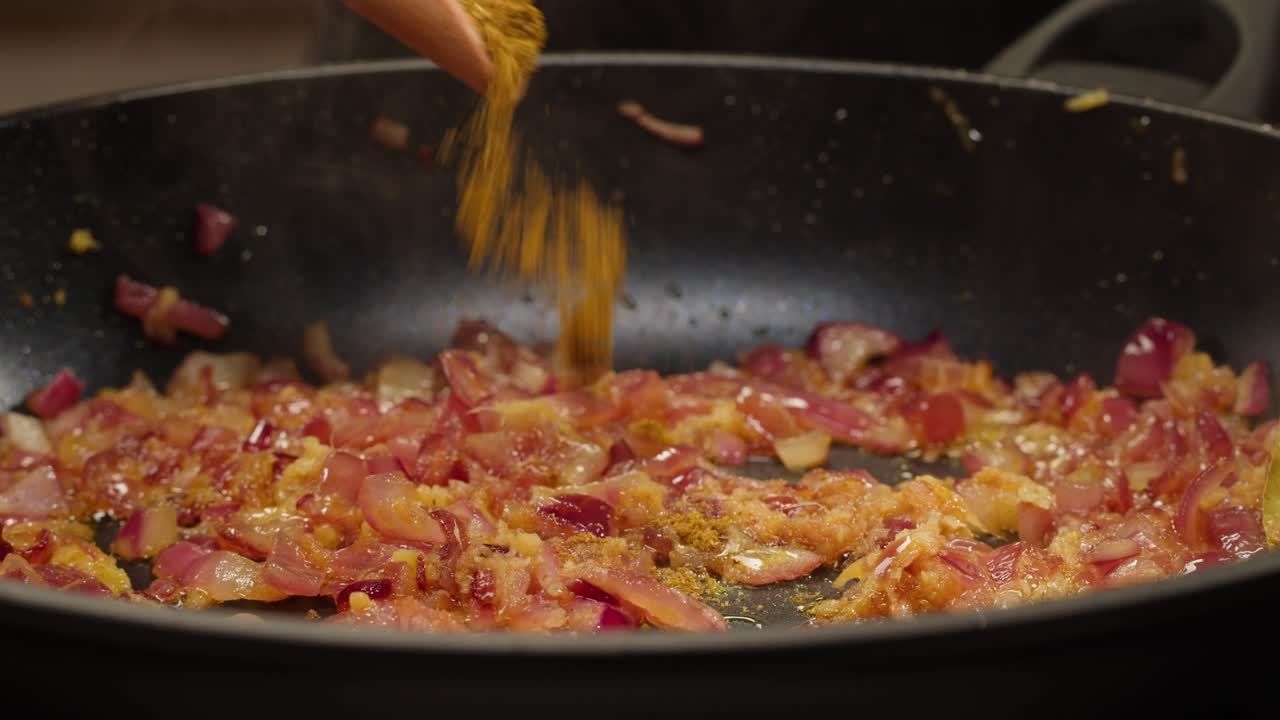 Cooking onions with spices in a pan