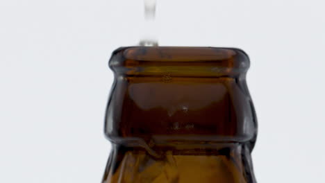 explosion lager beer bottle in super slow motion close up. wheat drink splashing