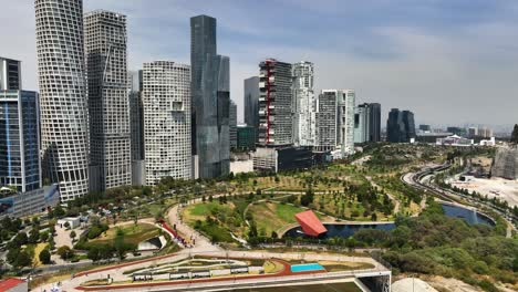 Aerial-view-backwards-away-from-the-La-Mexicana-park-in-sunny-Santa-Fe,-Mexico