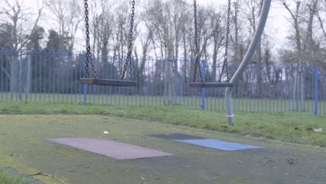 Still-swing-on-children-playground-with-no-people-on-a-cloudy-cold-day-in-central-London