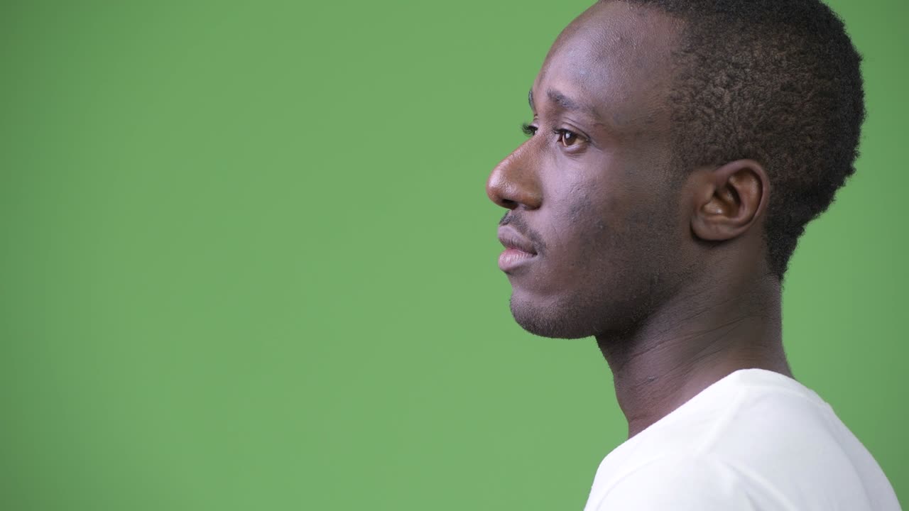 Rear view of young African man against green background