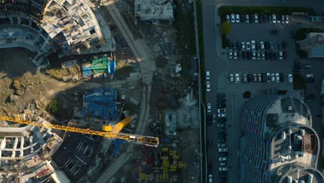 aerial view of urban construction site with parking lot and modern building