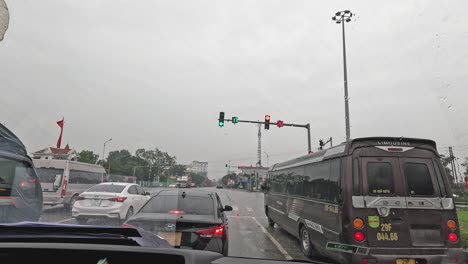 vehicles stopped at a red light in rain