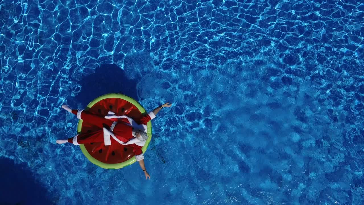 Party Santa in swimming pool on watermelon float