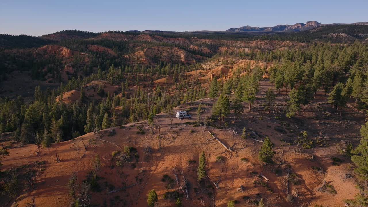 Ampia vista aerea di foresta di pini e creste di arenaria arancione attraverso l'altopiano della Dixie National Forest, Utah, panoramica con drone