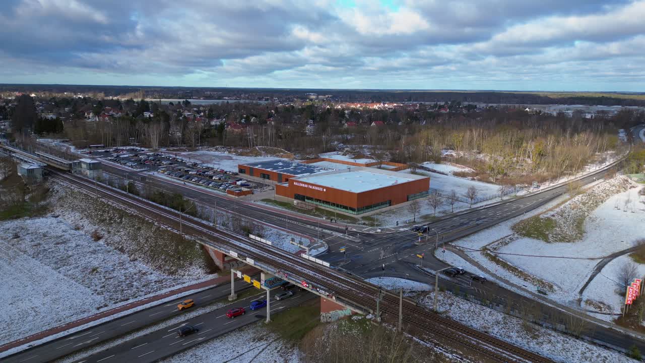 Indoor swimming pool with solar panels surrounded by snow and suburban homes in Falkensee Germany. Amazing aerial view flight static tripod hovering drone
