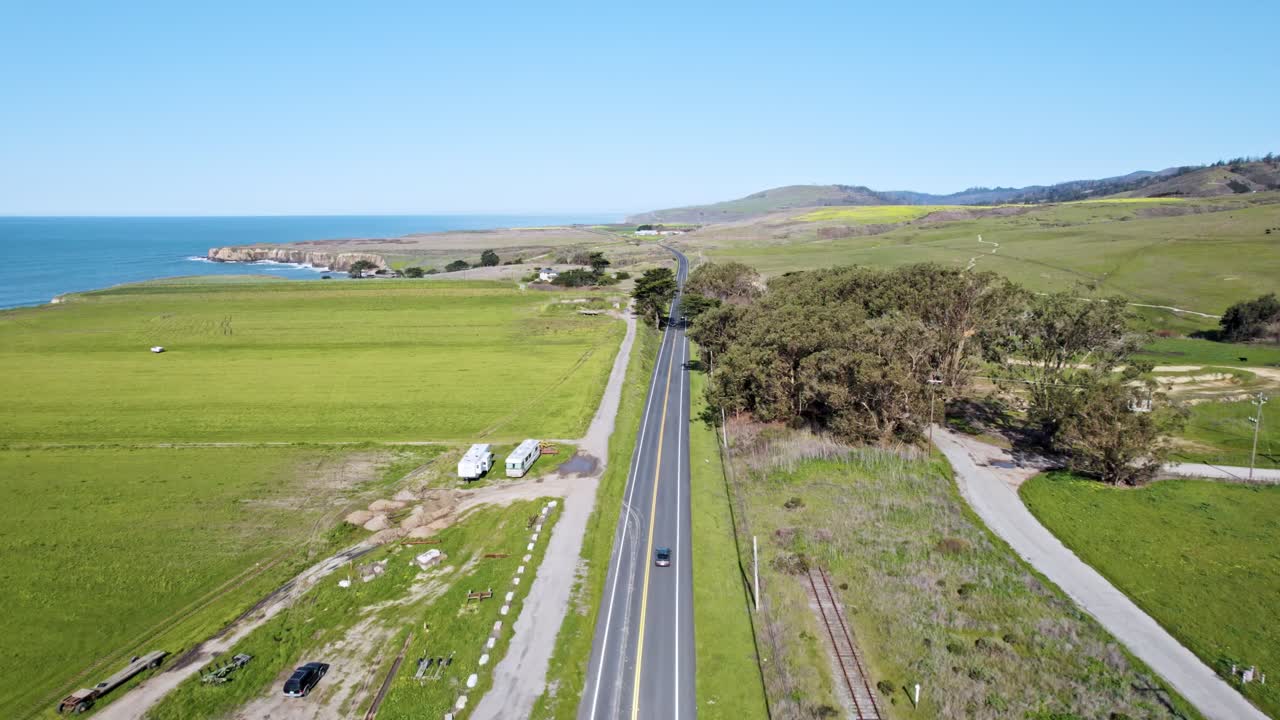 Aerial Drone View of a Car Driving Through Vast California Farmland on a Rural Road