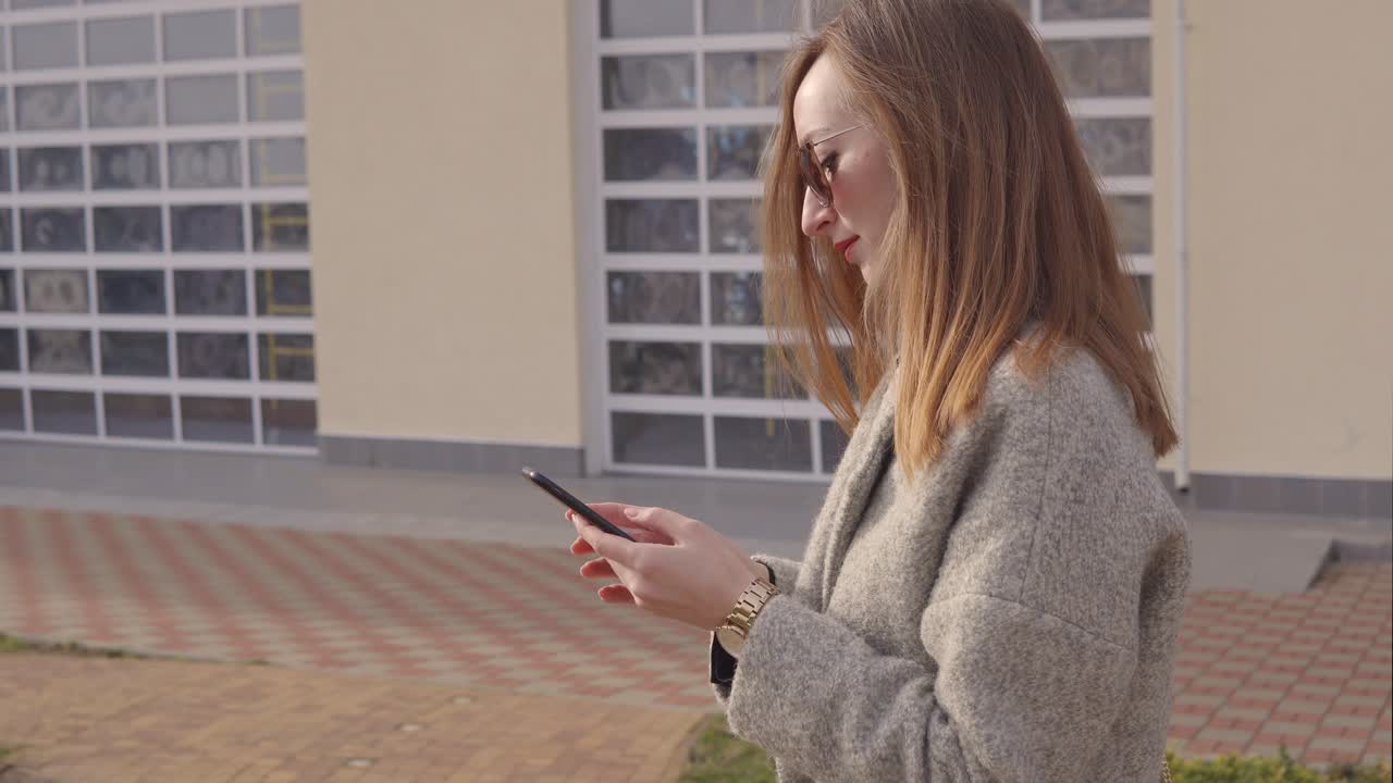 Donna che usa un telefono all'aperto