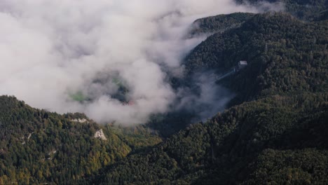 Fog-rolling-in-over-Power-substation-on-forest-covered-mountain-slope