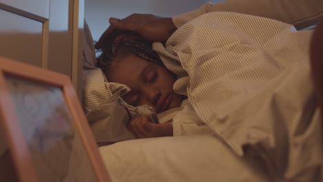 parent covering girl with blanket