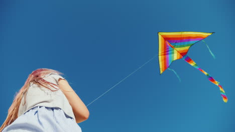 mujer joven jugando con la vista inferior de la cometa