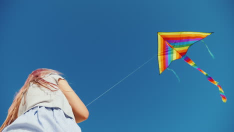 young woman playing with kite bottom view