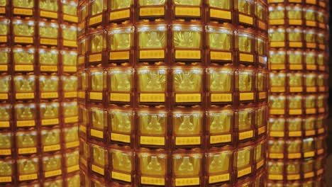 symmetrical view of golden buddha statues glowing in individual illuminated niches at ciyou temple in taiwan, symbolizing devotion, peace, and spiritual reverence in a sacred buddhist space