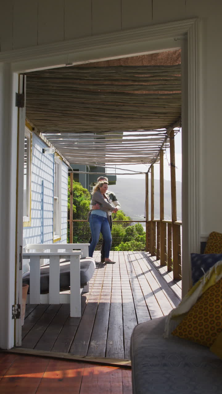 disparo vertical de una pareja caucásica bailando en un porche