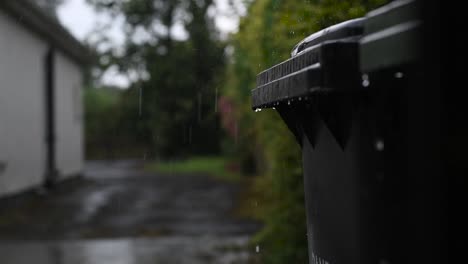 Gotas-De-Lluvia-Goteando-De-Las-Tapas-De-Los-Contenedores-Con-Ruedas-En-Cámara-Lenta