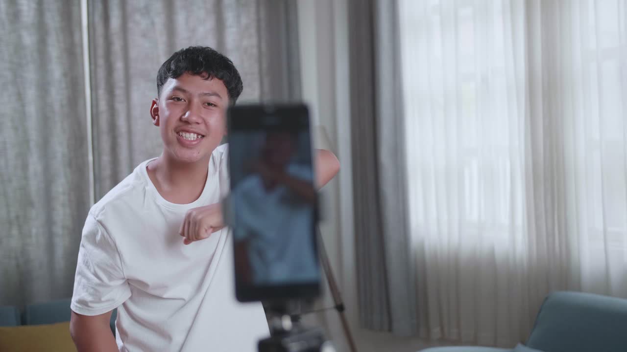 Asian Boy Dancing While Shooting Video Content For Social Networks With A Smartphone Camera