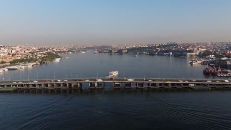 timelapse of cars crossing ataturk bridge as ferry boat passes along golden horn