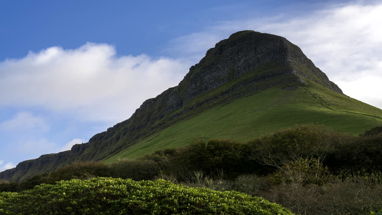 아일랜드의 카운티 슬라이고에 있는 벤불벤 산에서 움직이는 구름이 있는 풀밭과 나무의 시골 농업 풍경의 시간 경과