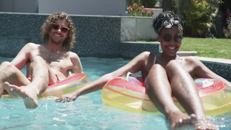 young couple enjoys a sunny day in the pool