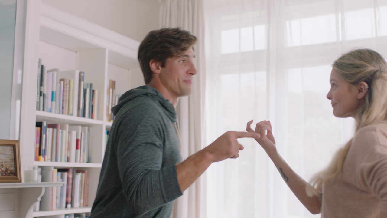 행복한 젊은 커플이 집에서 춤을 추고 축하하고 즐거운 주말을 함께 즐기고 거실에서 재미있는 춤을 즐기고 성공적인 관계 축하 4k 영상