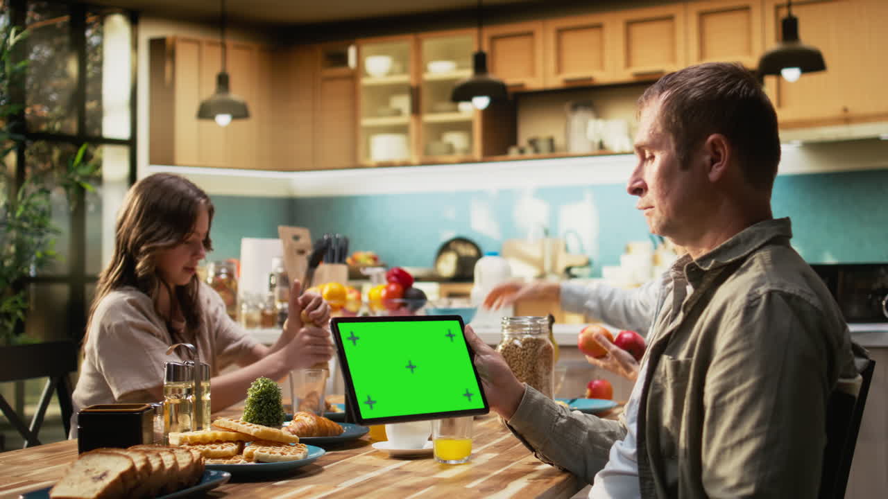 Mockup screen on tablet with father gathered for breakfast with his family