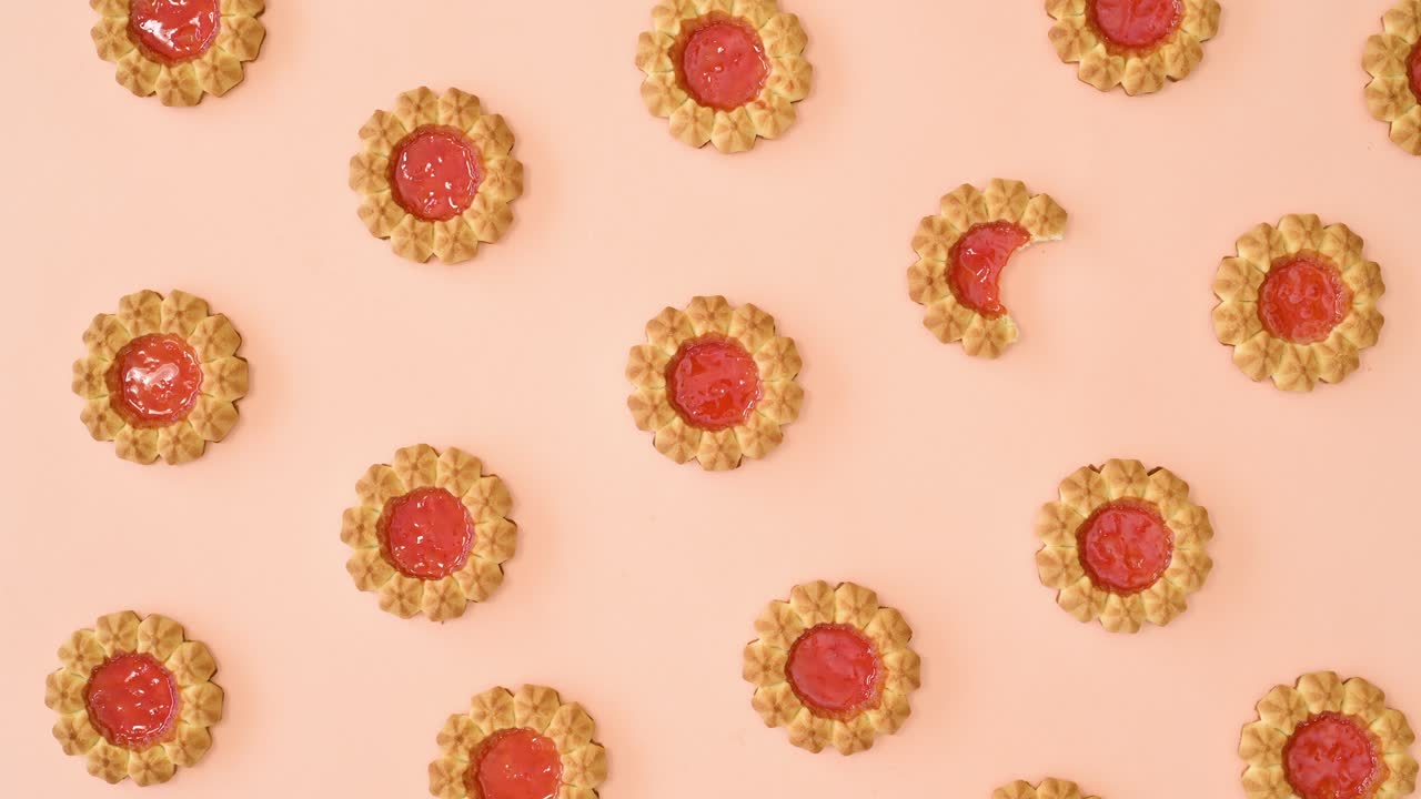 patrón de colocación plana de movimiento de parada en bucle con galletas con esmaltado naranja en fondo naranja brillante pastel