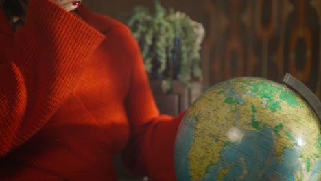 woman with a coffee cup and a vintage globe