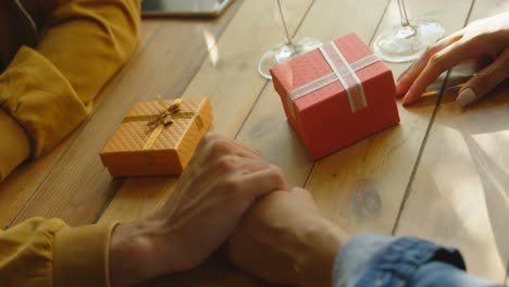 Close-up-of-romantic-mixed-race-couple-holding-hands-in-cafe-4k