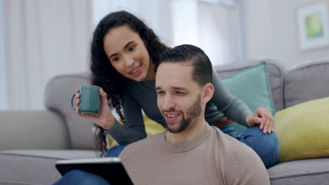 pareja feliz, hablando o tableta en el sofá