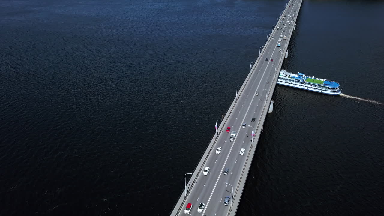 페리가 강을 가로지르는 다리를 건너고 있다