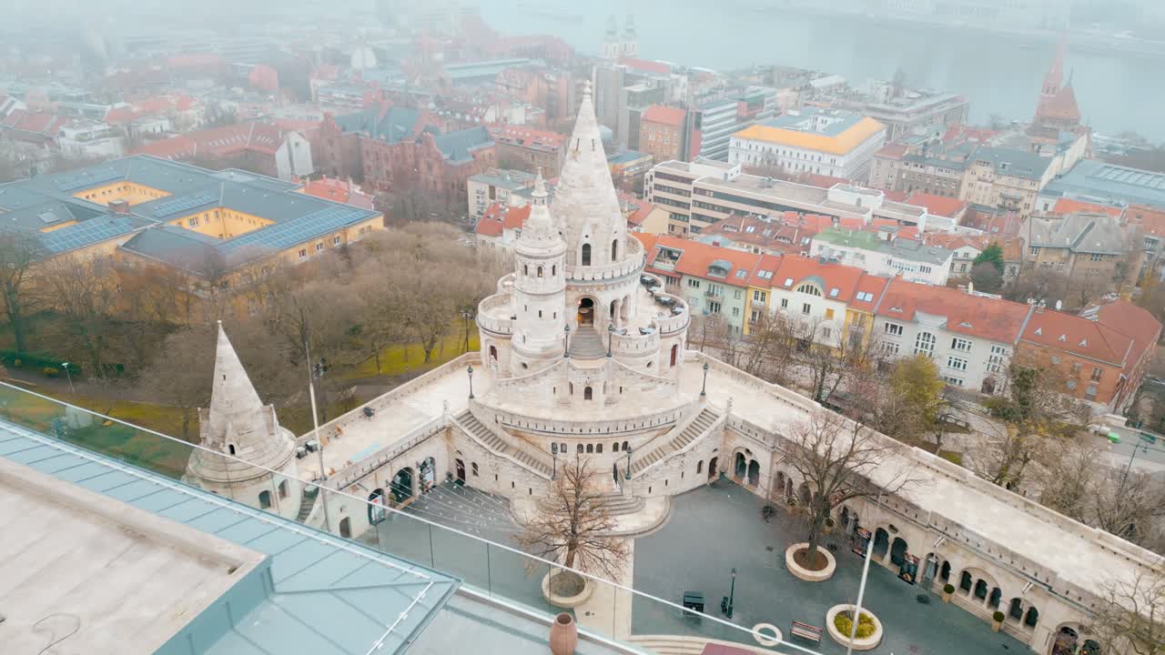 Cinematic aerial movement away from the Fisherman's Bastion, as misty clouds drift into frame on a cold winter morning in December