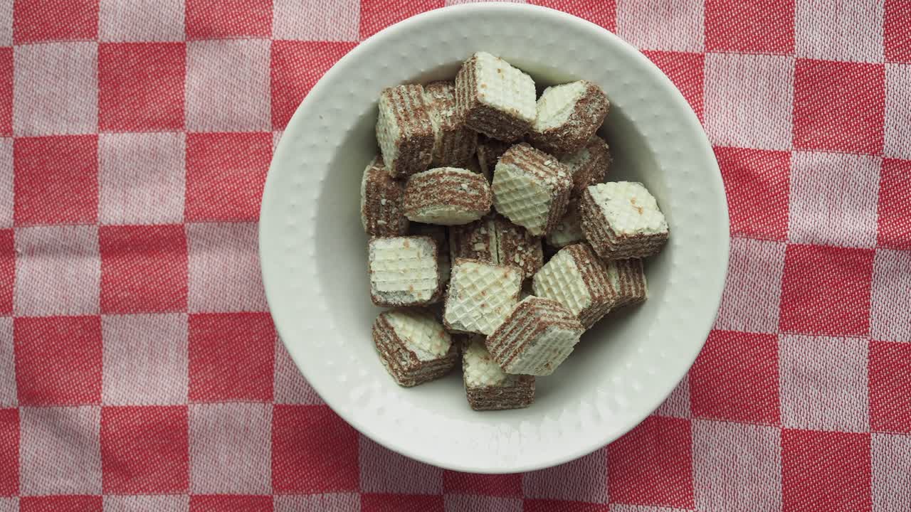 Wafer al cioccolato in una ciotola bianca su una tovaglia a quadri